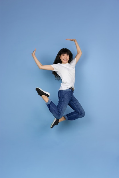 Joven, mujer asiática, en, pared azul