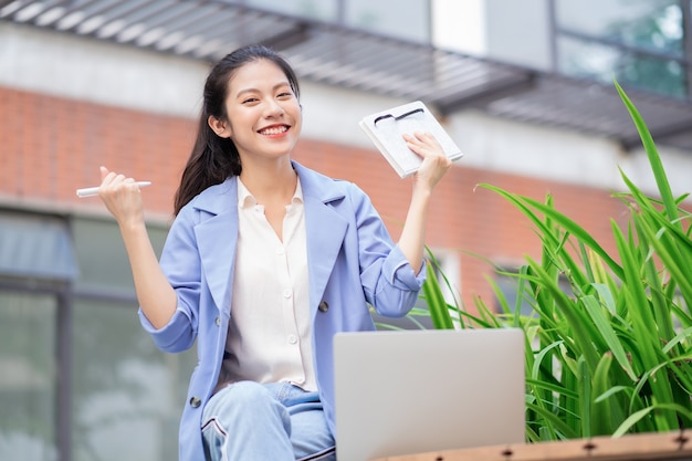 Joven, mujer asiática, trabajando, exterior