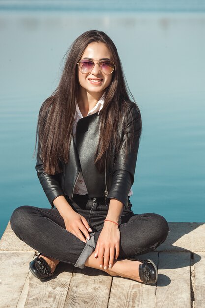 Joven mujer atractiva al aire libre. Hermosa mujer sobre un fondo de mar en el tiempo de otoño