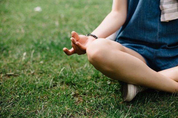 Joven mujer atractiva meditar en el parque.