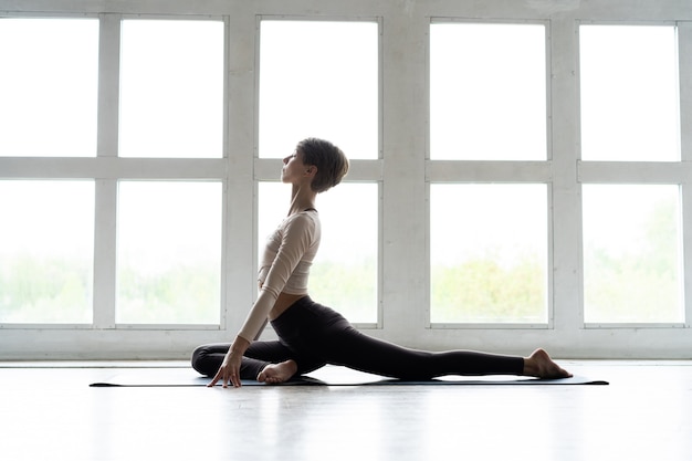 Joven mujer atractiva sonriente practicando yoga