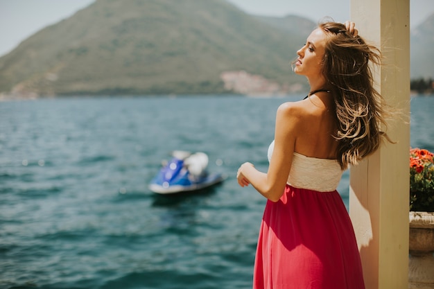 Joven mujer atractiva en un vestido de relax junto al mar en un día soleado