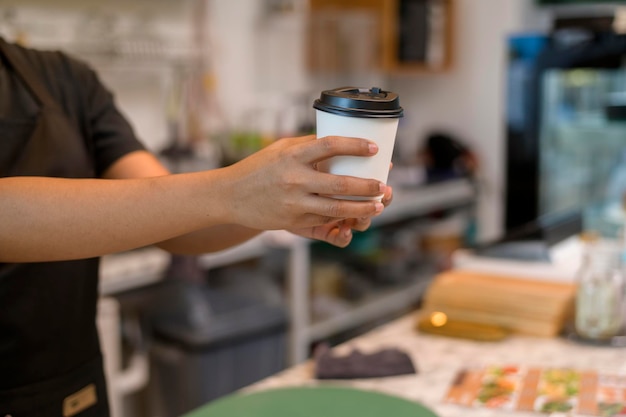 Joven mujer barista con mentalidad de servicio que trabaja en una cafetería