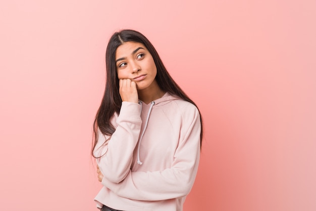 Joven mujer bastante árabe con look casual deportivo que se siente triste y pensativo,.