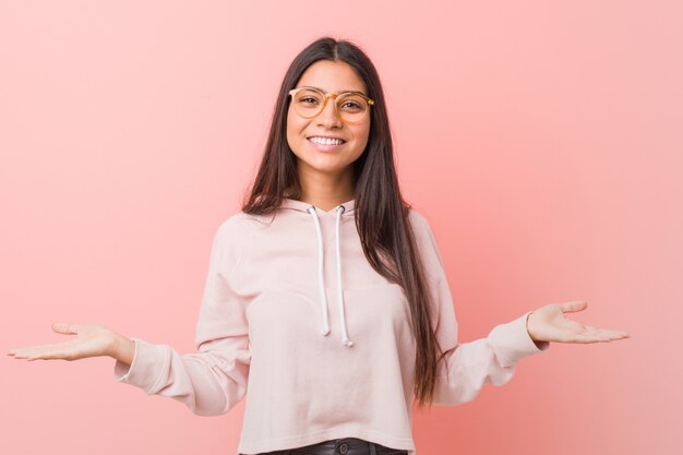 Joven mujer bastante árabe con un look deportivo casual que muestra una expresión de bienvenida.