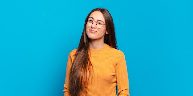 Joven mujer bastante casual que parece feliz y amigable, sonriendo y guiñando un ojo con una actitud positiva