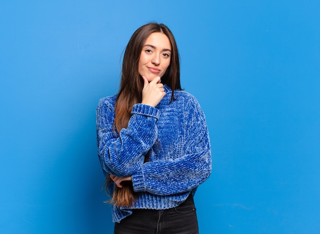 Joven mujer bastante casual que parece seria, confundida, insegura y pensativa, dudando entre opciones o elecciones