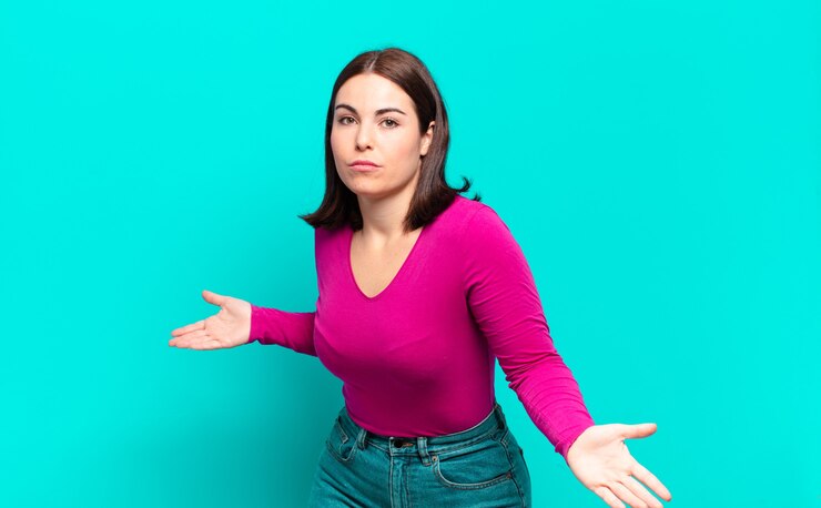 Foto joven mujer bastante casual que se siente despistada y confundida, sin tener idea, absolutamente desconcertada con una mirada tonta o tonta