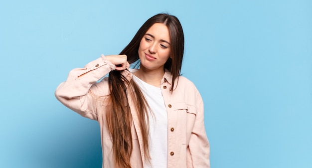 Joven mujer bastante casual que se siente estresada, ansiosa, cansada y frustrada, tirando del cuello de la camisa, luciendo frustrada con el problema