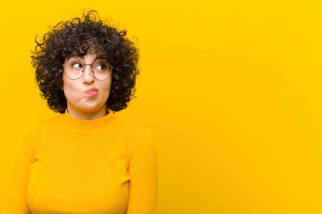 Foto joven mujer bonita afro mirando confundido