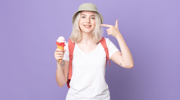 Joven mujer bonita albina sonriendo con confianza apuntando a poseer una amplia sonrisa concepto de verano