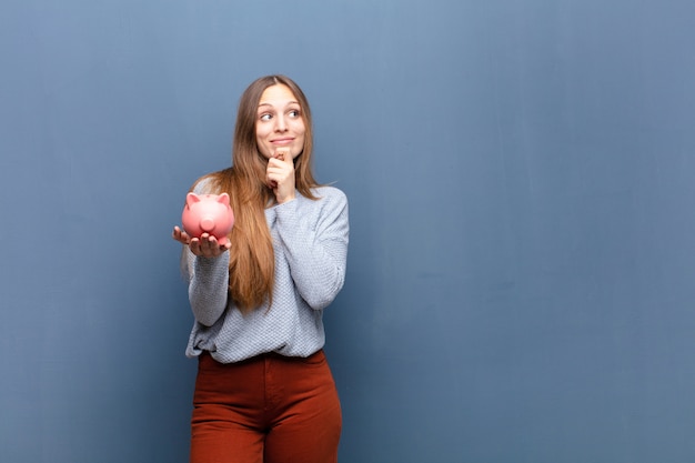 Joven mujer bonita con una alcancía