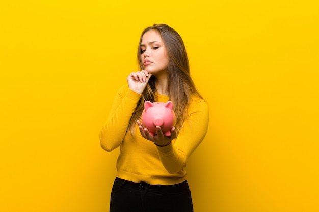 Joven mujer bonita con una alcancía