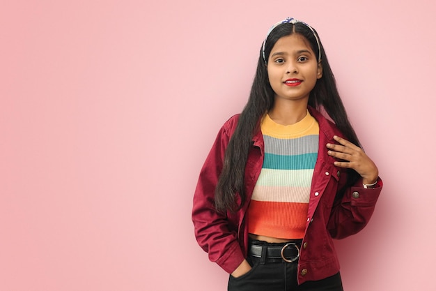 Joven mujer bonita asiática india que se siente feliz y enamorada sonriendo con una mano al lado del corazón y la otra en el bolsillo con espacio para copiar