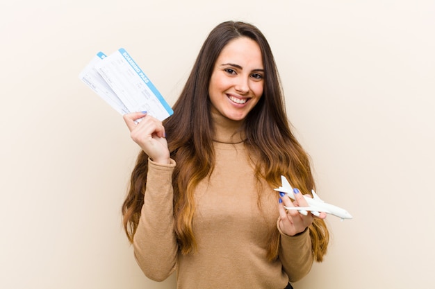 Joven mujer bonita con un avión de embarque entradas