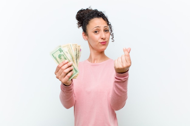 Foto joven mujer bonita con billetes de pared blanca