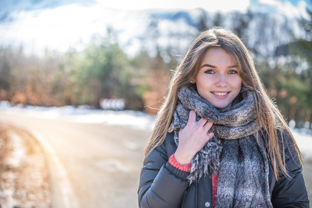 Foto joven mujer bonita en una carretera con nieve en invierno