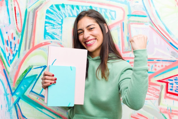 Joven mujer bonita contra la pared de graffiti