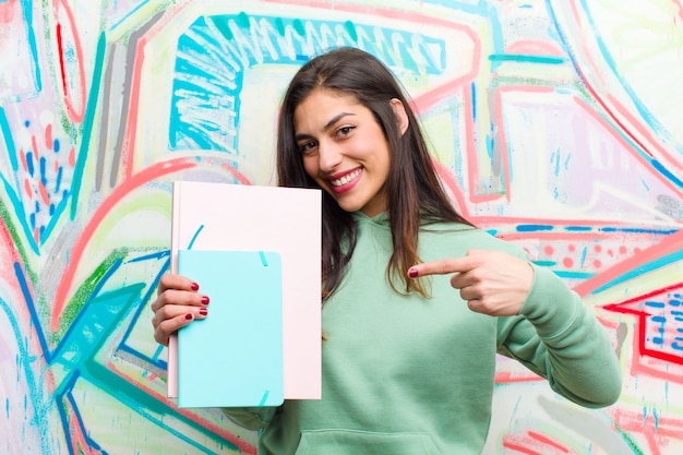 Joven mujer bonita contra la pared de graffiti