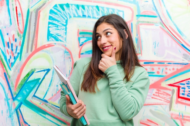 Joven mujer bonita contra la pared de graffiti