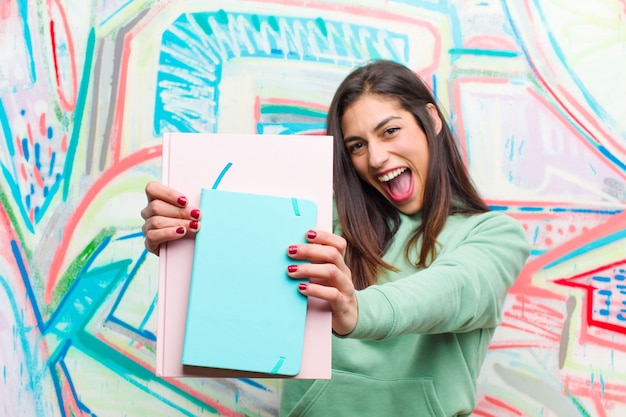 Joven mujer bonita contra la pared de graffiti