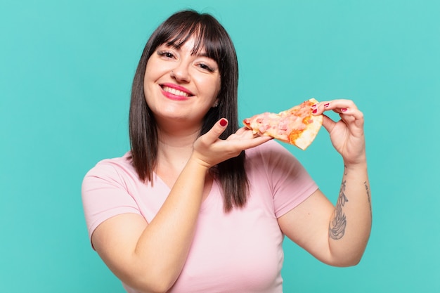 Joven mujer bonita con curvas feliz expresión y sosteniendo una pizza