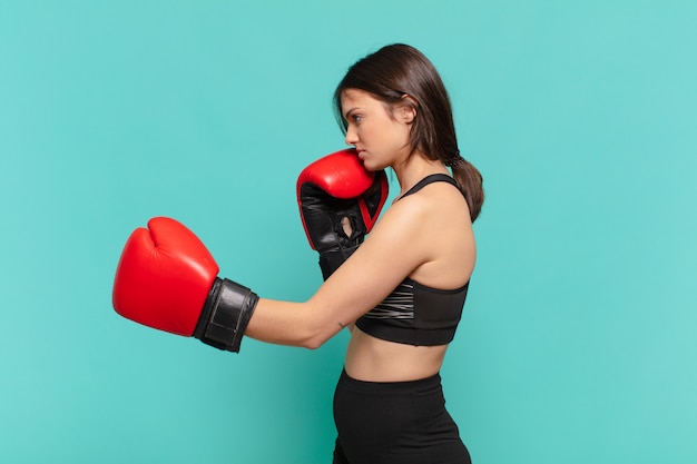 Joven mujer bonita deporte expresión enojada y guantes de boxeo