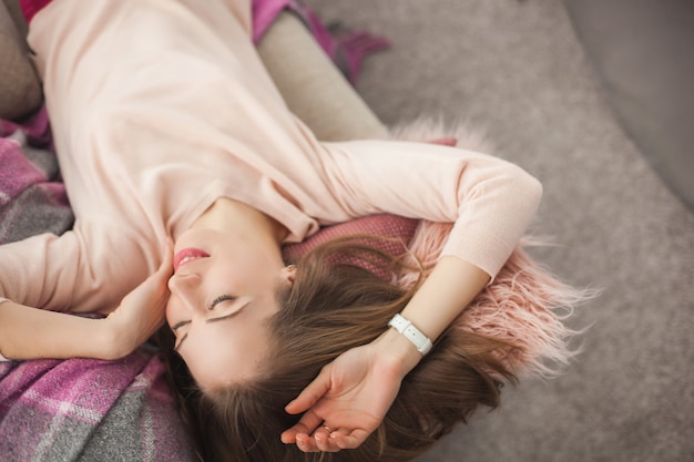 Joven mujer bonita descansando en casa. Bella dama tumbada en el sofá