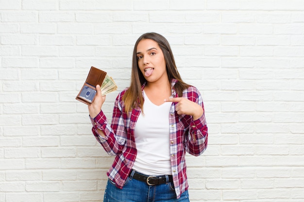 Joven mujer bonita con un et contra la textura de la pared de ladrillo