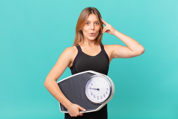 Joven mujer bonita fitness mirando sorprendido, dándose cuenta de un nuevo pensamiento, idea o concepto