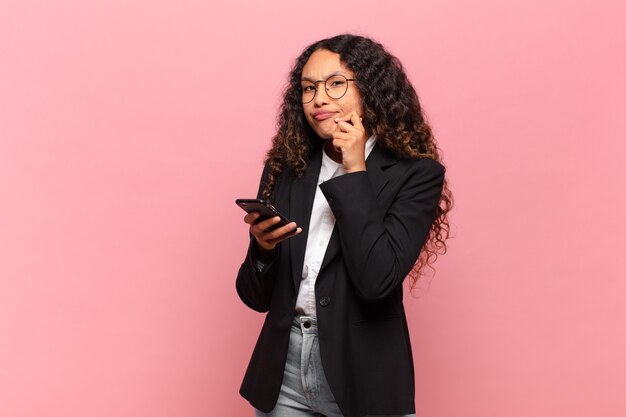 Joven mujer bonita hispana concepto de negocio y teléfono inteligente