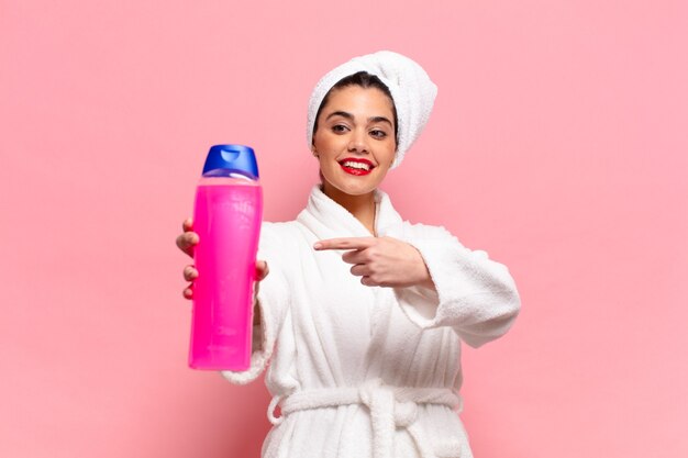 Joven mujer bonita hispana feliz y sorprendido concepto de productos de ducha de expresión