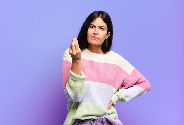 Foto joven mujer bonita hispana haciendo capice o gesto de dinero, ¡diciéndole que pague sus deudas!