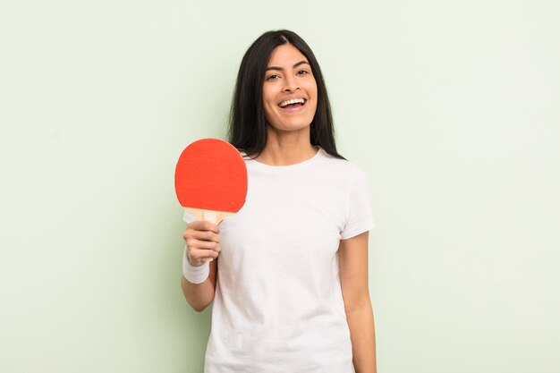 Joven mujer bonita hispana que parece feliz y gratamente sorprendida concepto de ping pong
