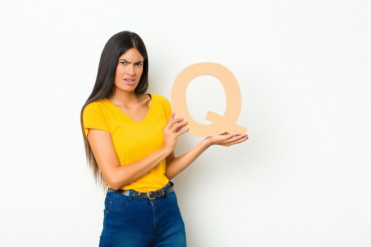 Foto joven mujer bonita latina confundida, dudosa, pensando, sosteniendo la letra q del alfabeto para formar una palabra o una oración