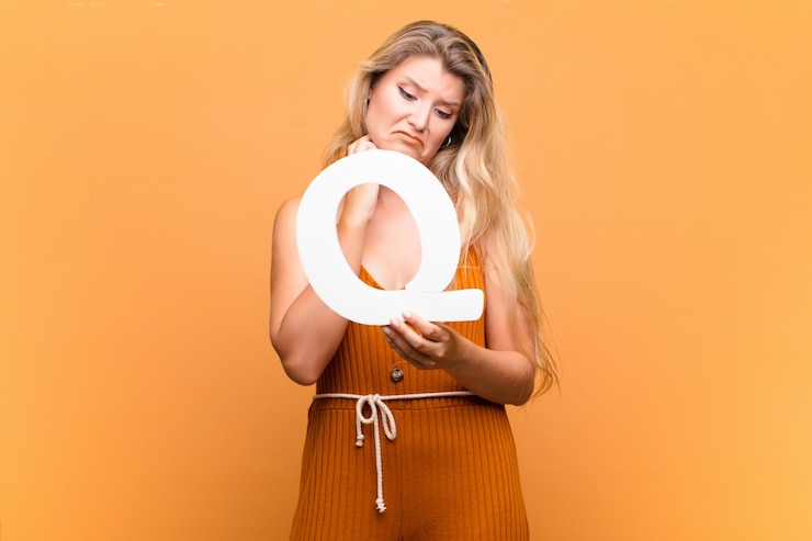 Foto joven mujer bonita latina triste, deprimida, infeliz, sosteniendo la letra q