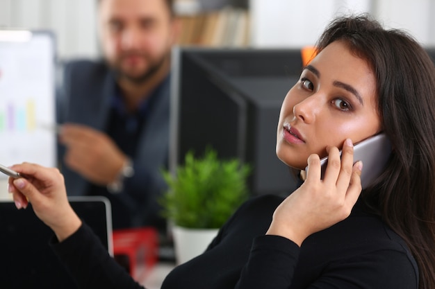 Foto joven mujer bonita morena en el trabajo de oficina con su jefe