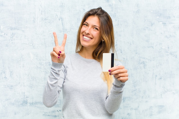 Foto joven mujer bonita con una pared de grunge de tarjeta de crédito