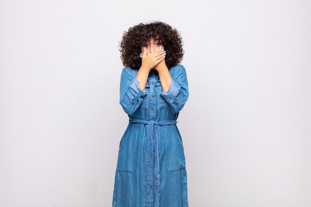 Joven mujer bonita con pelo rizado y vestido de jeans