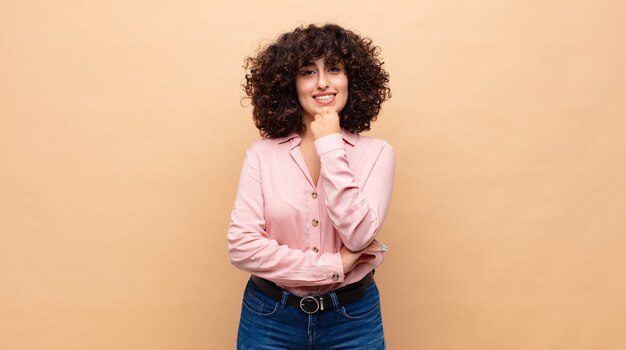 Foto joven mujer bonita con pelo rizado