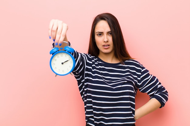 Joven mujer bonita con un reloj. concepto de tiempo