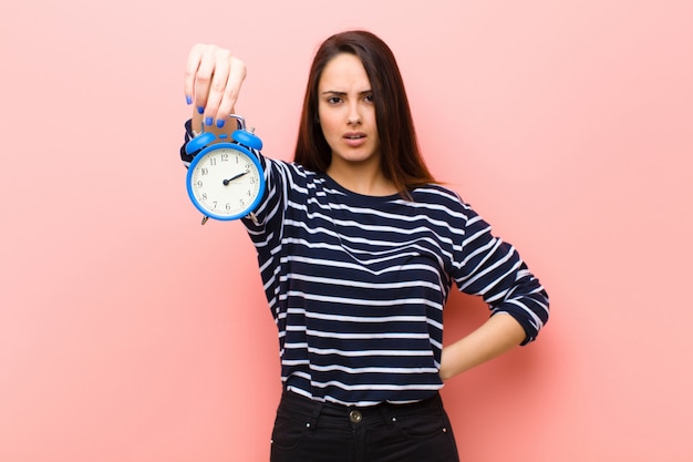 Foto joven mujer bonita con un reloj. concepto de tiempo