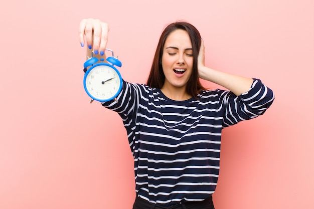 Joven mujer bonita con un reloj. concepto de tiempo