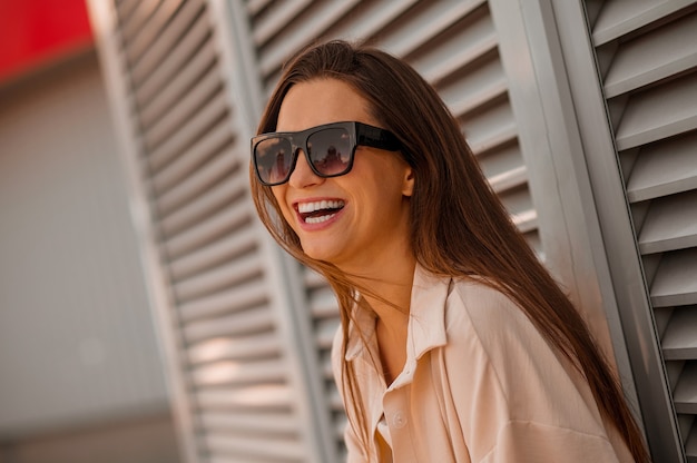 Una joven mujer bonita con ropa beige y gafas de sol