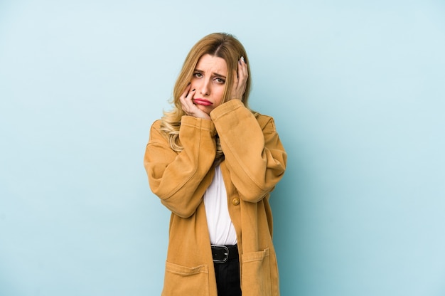 Joven mujer bonita rubia aislada lloriqueando y llorando desconsoladamente.