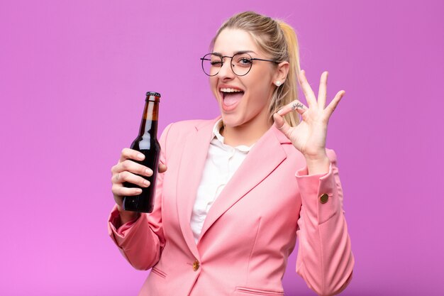 Joven mujer bonita rubia tomando una cerveza