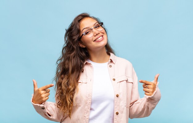 joven mujer bonita sobre fondo azul con gafas