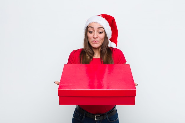 Joven mujer bonita con sombrero de santa. Concepto de navidad.