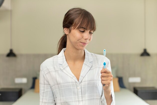 Foto joven mujer bonita sonriendo y mirando con un feliz concepto de enjuague bucal de expresión segura