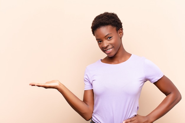 Joven mujer bonita sonriendo, sintiéndose segura, exitosa y feliz, mostrando el concepto o idea en el espacio de copia al lado